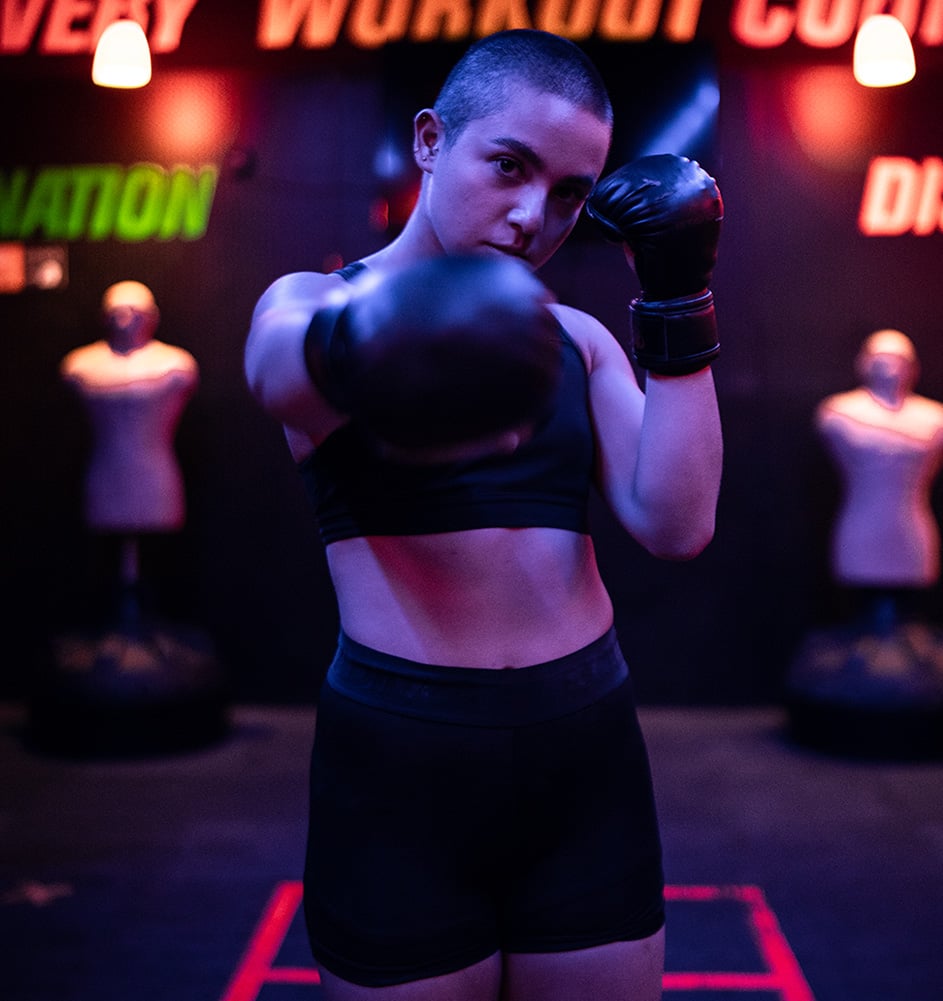 a woman in a black sports bra and boxing gloves